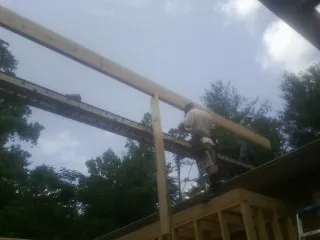 Carpenter setting a ridge beam over a new addition frame — Ice Dam Removal by Roofing Brothers in Oldwick