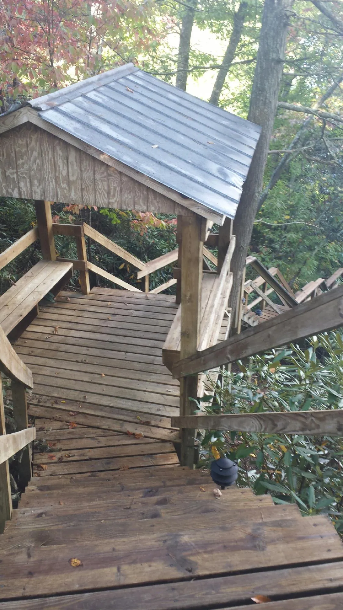 Metal roofed shelter over wooden steps on a wooded walkway — Skylight Repair & Installation work by our crew in Oldwick
