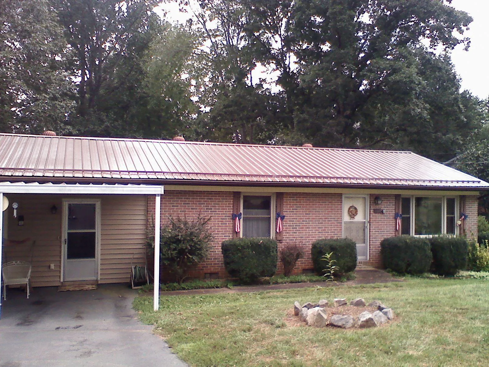 Bronze metal roof and carport on a brick ranch home — Roof Repair work by our crew in Oldwick