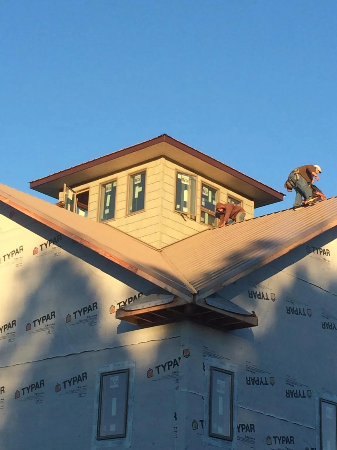 Roofers working around a rooftop cupola on a new metal roof at sunset — Roof Waterproofing in Oldwick by Roofing Brothers
